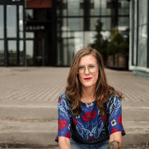 Elizabeth Korver Glenn sits on the stairs outside of a building
